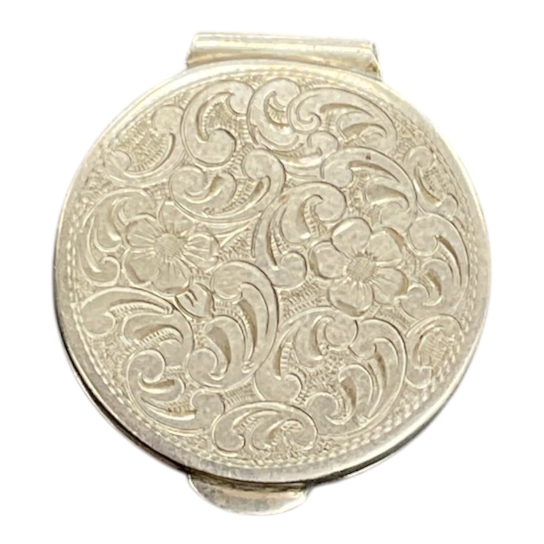 Sterling Silver Floral Engraved Pill Box: A small sterling silver pill box featuring an engraved floral and scroll motif across the lid. The circular form opens on a hinged lid to reveal a smooth interior compartment suitable for holding pill