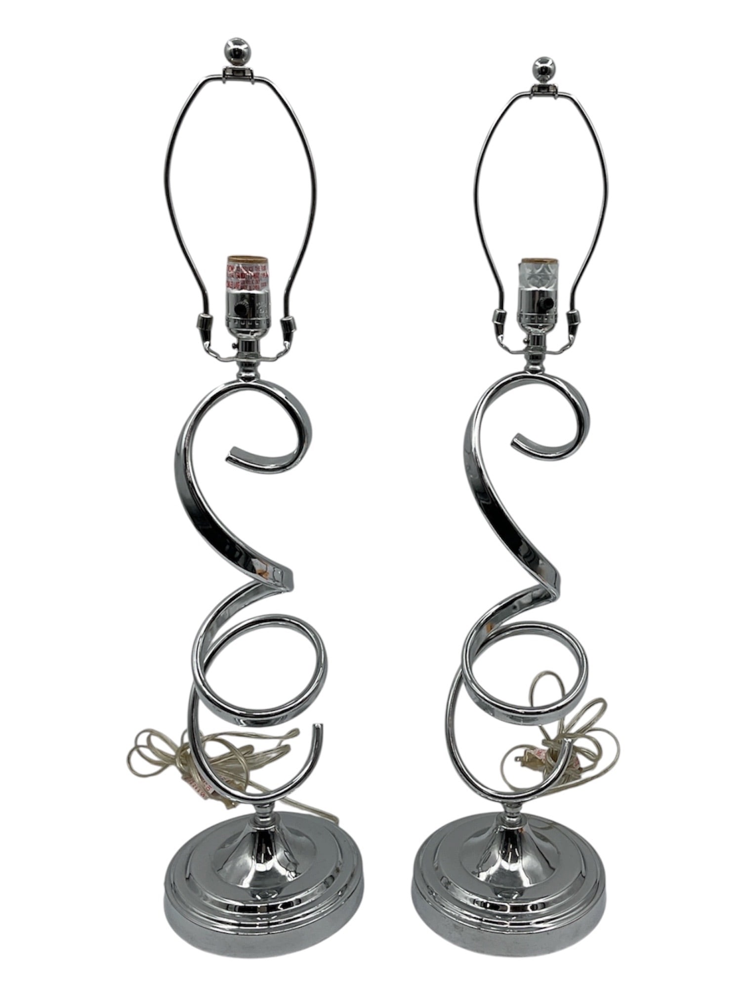 ORE International Industrial Table Lamp Set in Brushed Silver Coiled Metal Design: A pair of industrial-style table lamps by ORE International, featuring sculptural coiled metal bases in a brushed silver finish. The design showcases a striking spiral form rising from round bases, co