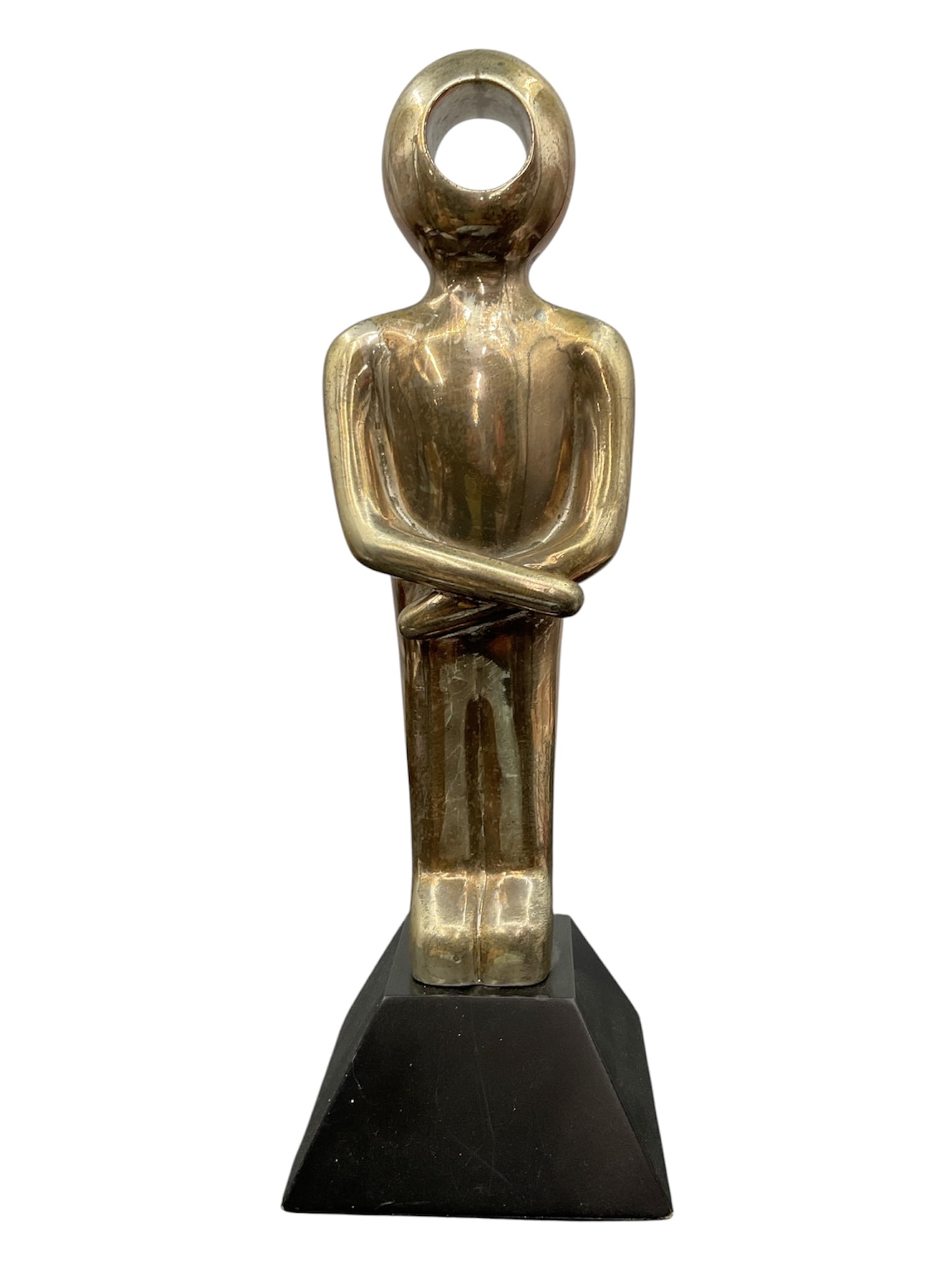 Modernist Metallic Figural Sculpture on Plinth Base: Contemporary modernist figural sculpture depicting a stylized standing human form with folded arms and circular openwork head. Finished in a metallic silver-tone surface and mounted on a black geometr