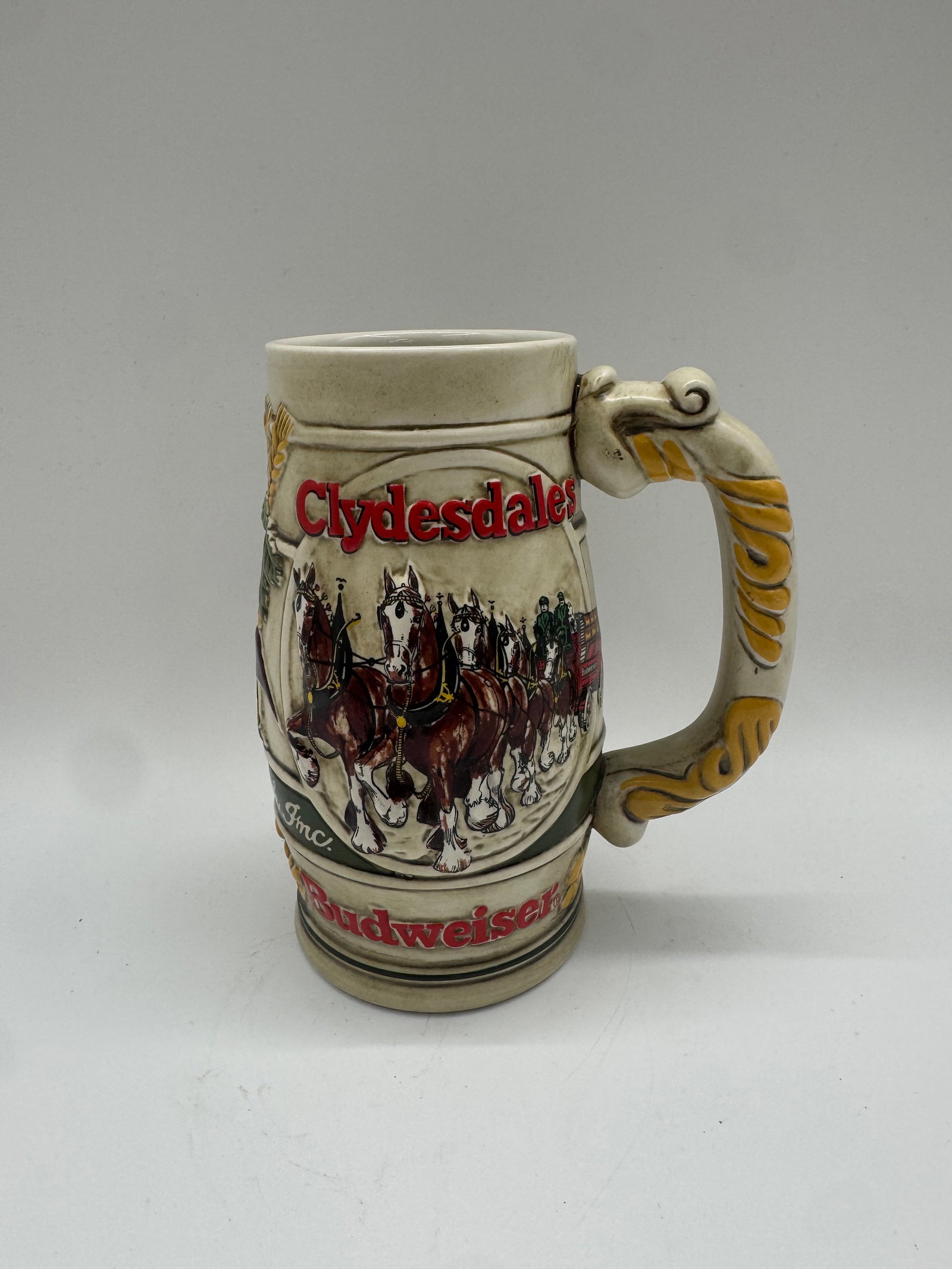 Budweiser “Clydesdales?? Beer Stein, Anheuser-Busch Collectors Stein: Classic Budweiser Clydesdales beer stein featuring the famous hitch in full relief, with the team of horses and red beer wagon wrapping around the body. Raised red le
