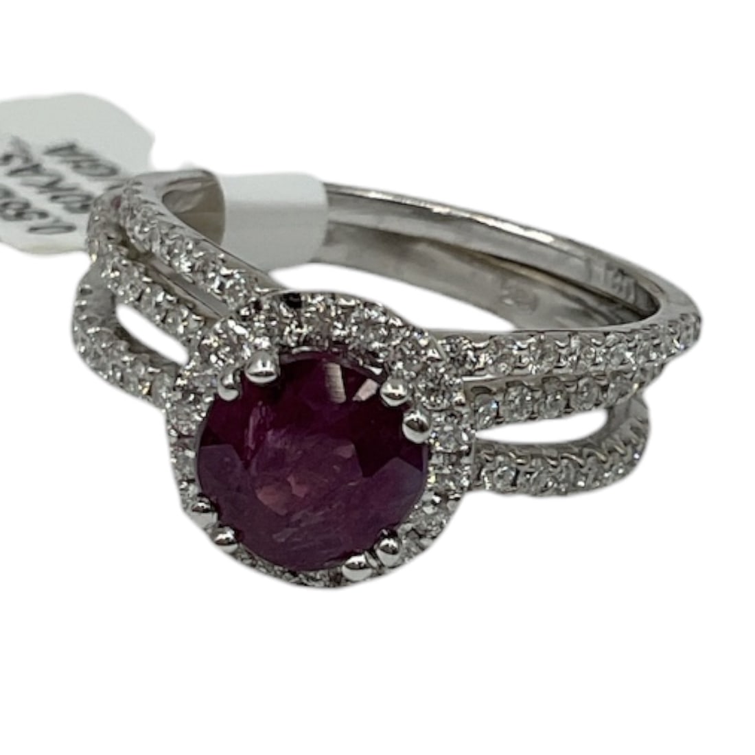 Platinum Kashmir Sapphire and Diamond Ring with GIA Report: An elegant platinum ring set with a round-cut purplish Kashmir sapphire, surrounded by a halo of round brilliant cut diamonds and additional diamonds extending along the split shoulders. The richly co