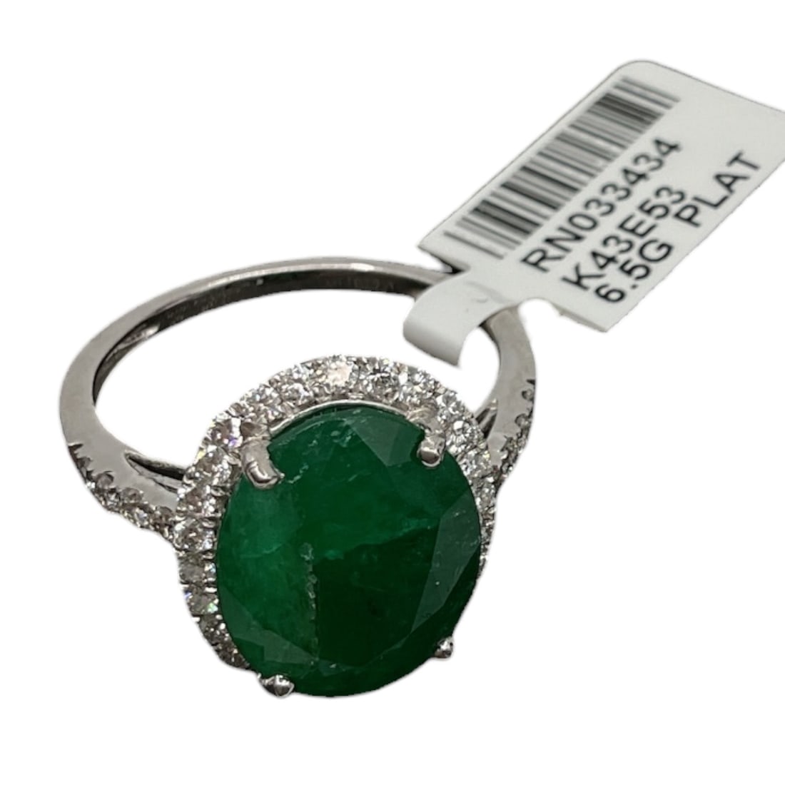 Platinum Emerald and Diamond Ring with Appraisal: An elegant platinum ring set with a vivid oval-cut green emerald at center, accented by a halo of round brilliant cut diamonds and additional diamonds along the shoulders. The rich green gemstone is c