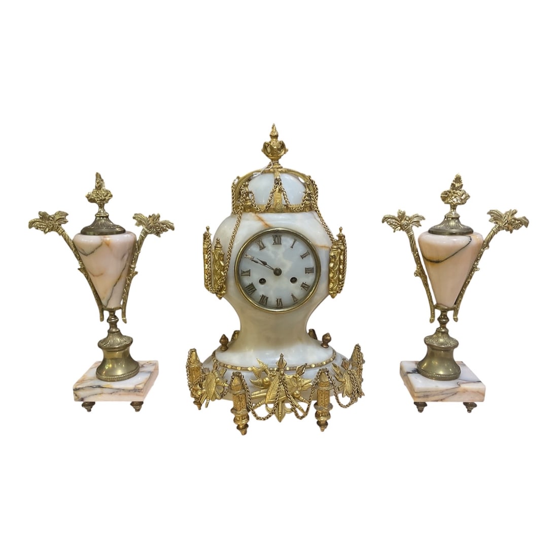 CK136 - French Style Onyx and Dore Bronze Three-Piece Mantel Clock Garniture: An elegant three-piece mantel clock garniture executed in the French classical taste, featuring a central clock accompanied by a matching pair of decorative urns, all crafted with luminous onyx and fi