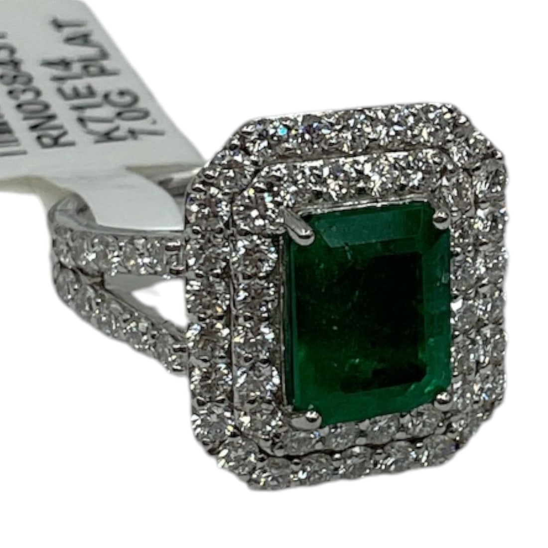 Oscar Friedman 18K White Gold Emerald and Diamond Ring with Appraisal: A luxurious ring by Oscar Friedman, crafted in 18K white gold and set with a vibrant emerald-cut green emerald at center. The centerpiece is framed by a double halo of round brilliant cut diamonds, wi
