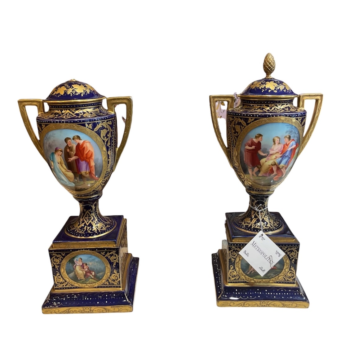 AQ428- Pair of 19th Century Royal Vienna Porcelain Covered Vases: A refined pair of porcelain covered vases executed in the Royal Vienna style, showcasing exceptional craftsmanship, rich cobalt blue grounds, and finely hand-painted figural reserves. These elegant ur