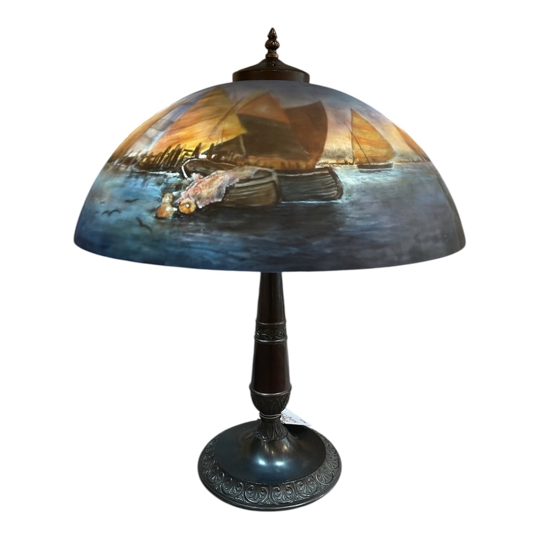 LM138 - Reverse Painted Glass Lamp with Nautical Harbor Scene: A beautifully atmospheric reverse painted table lamp, featuring a serene nautical harbor scene rendered in rich, blended tones. This decorative piece captures the charm and tranquility of coastal life