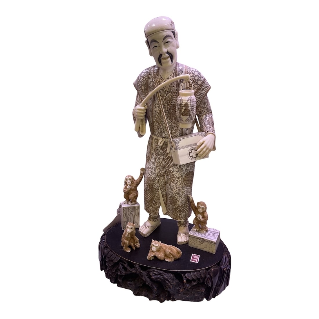 IC1388 - Carved Asian Figure of Man with Monkeys on Hardwood Base: A finely detailed carved figure depicting a sta