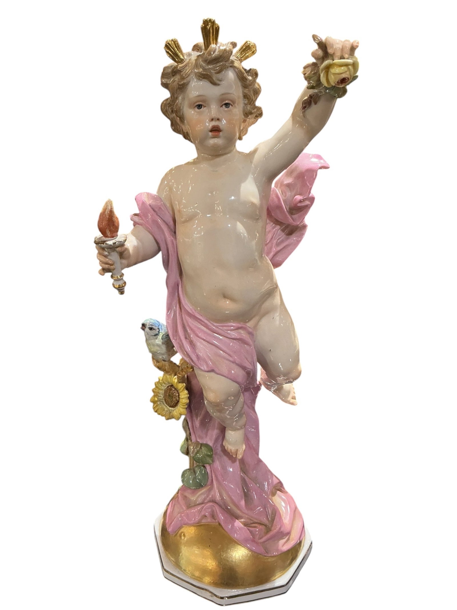 PC155 - Meissen Porcelain Cherub Figure with Flowers and Bird: A beautifully modeled Meissen porcelain figure depicting a cherub in a lively and expressive pose, richly decorated with floral and naturalistic elements. This piece exemplifies the refined craftsmans
