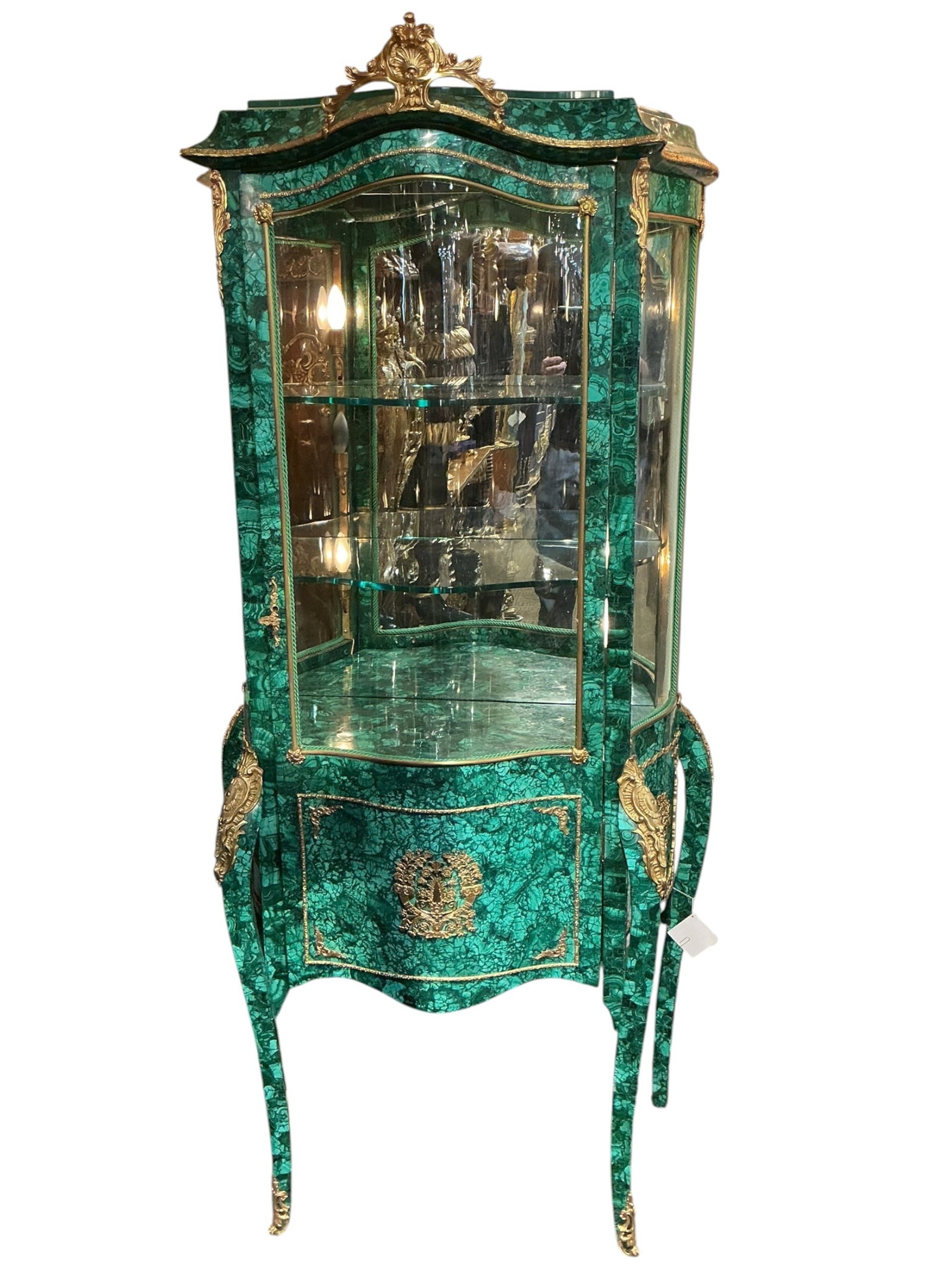 MC144- 19th Century French Malachite and Dore Bronze Vitrine: An exceptional 19th century French vitrine cabinet, richly veneered in striking malachite and adorned with elaborate dore bronze mounts. The cabinet features a gracefully shaped form with a bowed