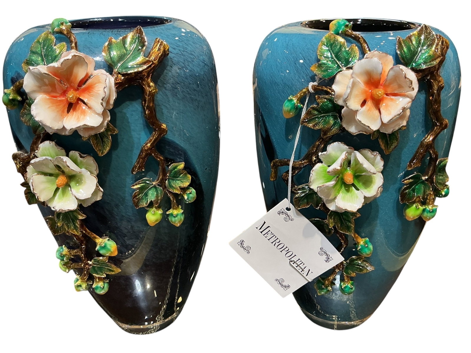 CS1051- Pair of Blue Crystal and Enamel Mounted Vases with Floral Decoration: A decorative pair of blue crystal vases enhanced with finely applied enamel floral motifs, executed in a refined European style. Each vase features a softly contoured, tapering form crafted in translu