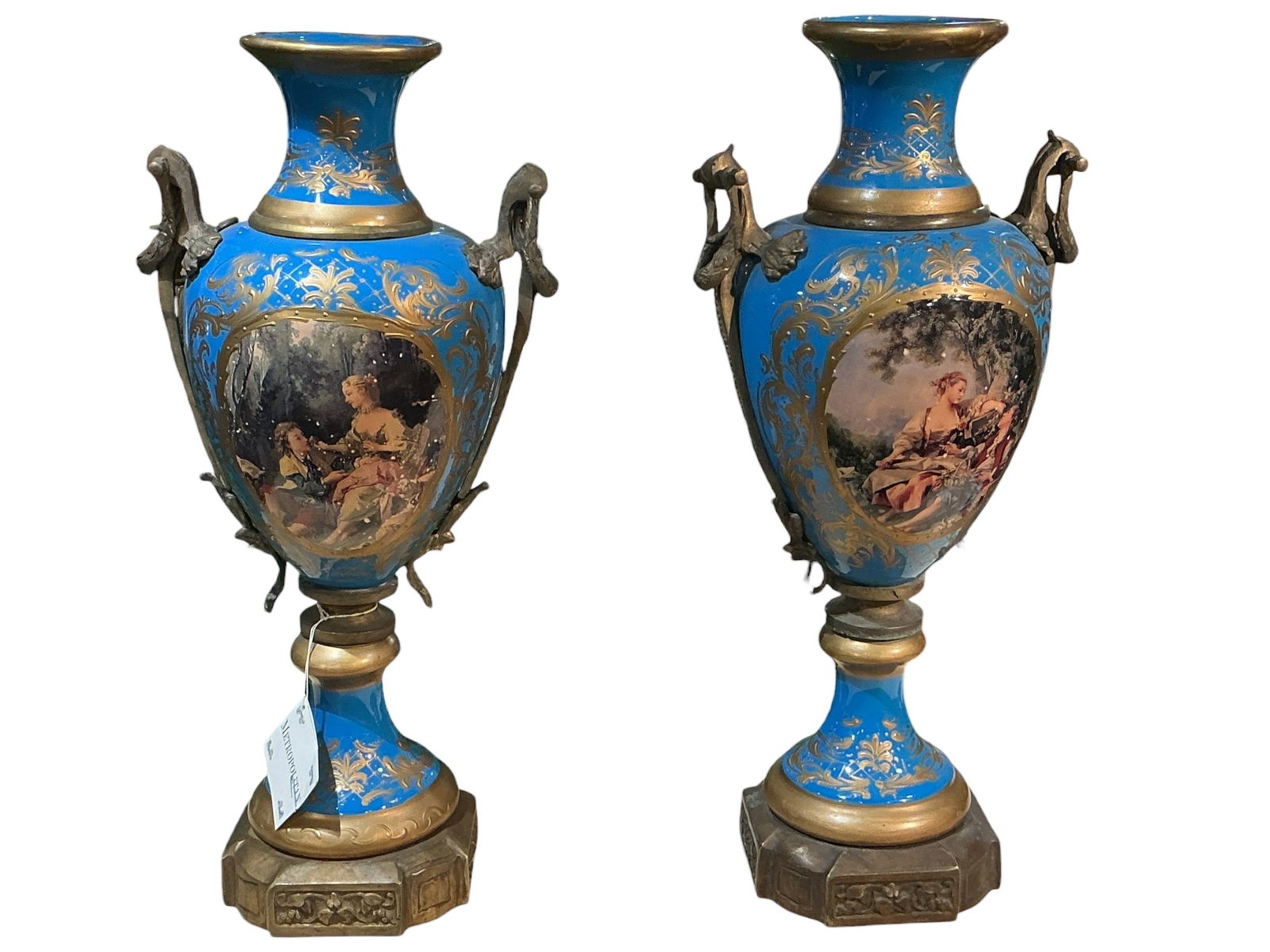 PC747 - Pair of 19th Century Sevres Style Porcelain and Dore Bronze Mounted Vases: A refined pair of 19th century Sevres style porcelain vases mounted with dore bronze, executed in a classical French design. Each vase is formed in an elegant urn shape with a flared neck, rounded bod