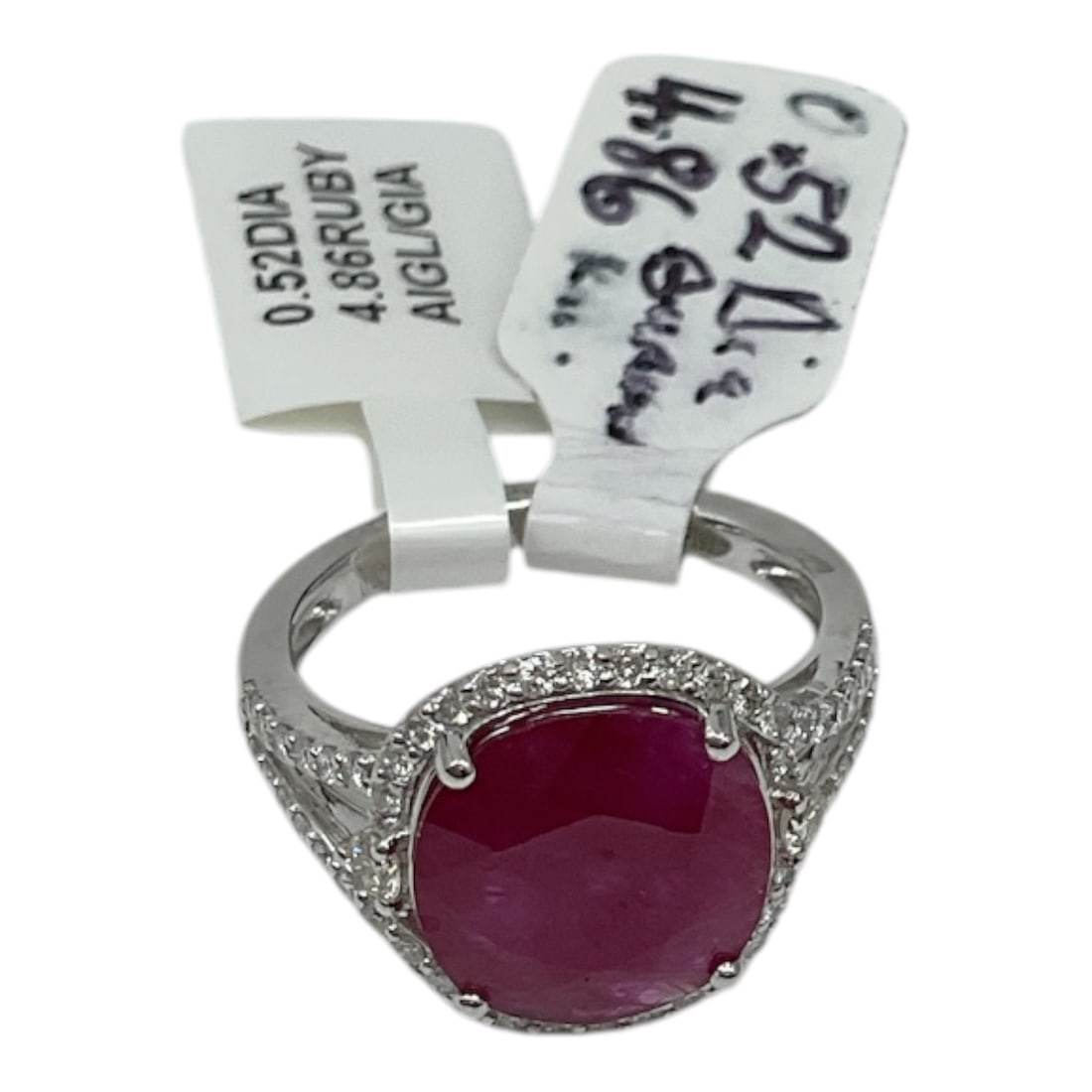 14K White Gold Ruby and Diamond Ring with AIGL Appraisal: An elegant ring crafted in 14K white gold, featuring a vivid oval-cut ruby at center. The rich red gemstone is accented by round brilliant cut diamonds along the halo and shoulders, enhancing the over