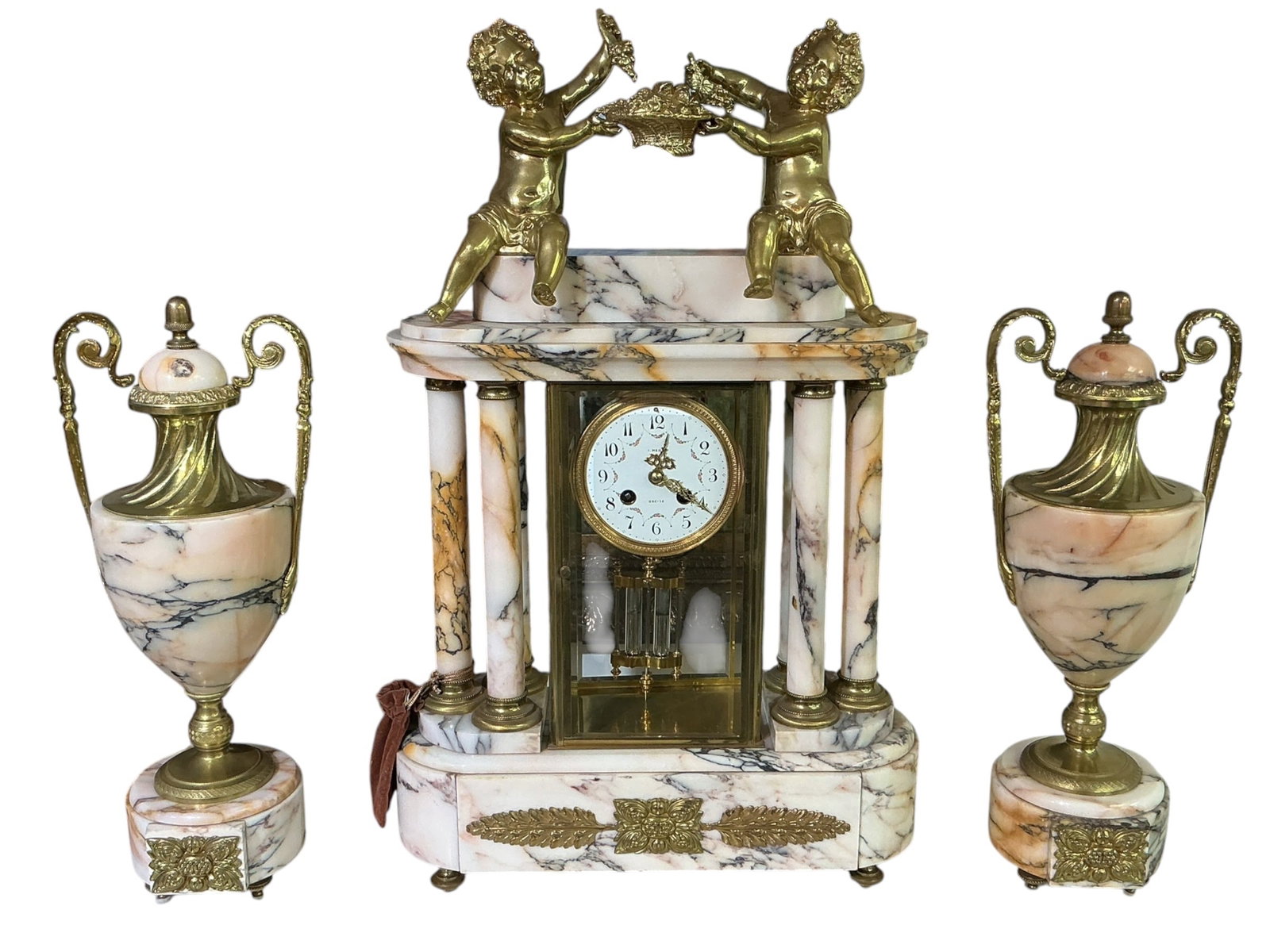 CK188 - Circa 1860 French Marble and Dore Bronze Three-Piece Clock Garniture: An elegant circa 1860 French three-piece clock garniture, crafted in marble and richly adorned with dore bronze mounts. The set includes a central mantel clock flanked by a matching pair of decorative