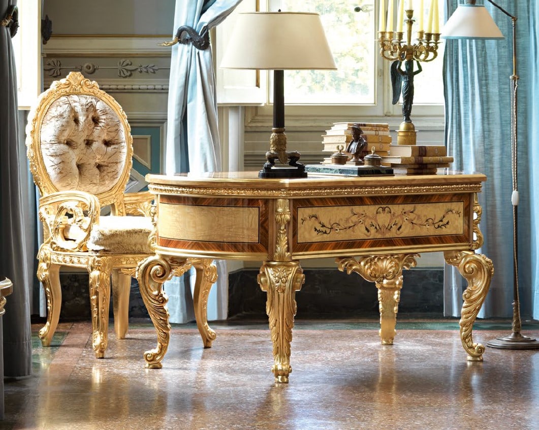 SOCCI VERSAILLES DESK & ARMCHAIR: Luxuriously ornate writing desk in a rich golden finish, featuring intricately carved legs and borders. The front panels showcase elegant marquetry inlays with floral motifs framed in contrasting