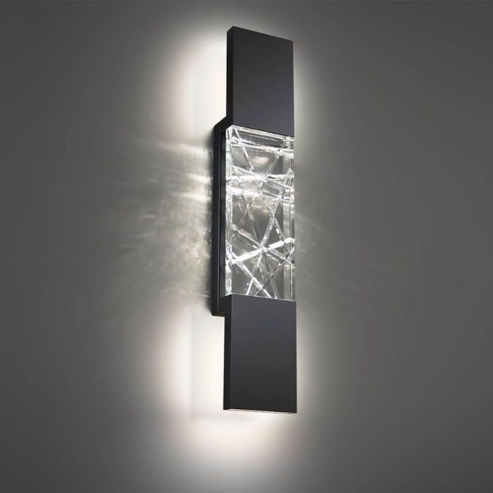 Schonbek Beyond Glacier Wall Sconce: The Glacier Wall Sconce unites bold geometric angles using clear crystal in an interlocking pattern, delvering a textured backlit illumination provided by the hidden LEDs within. Its black base is per