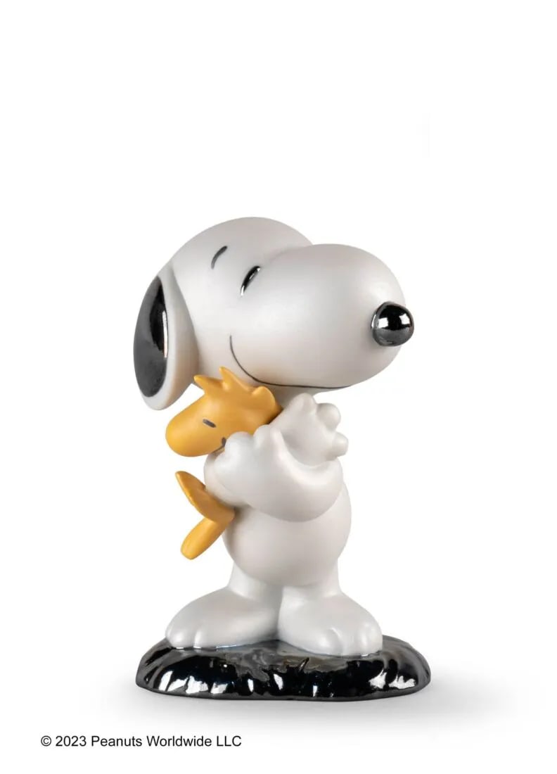 LLADRO Snoopy Figurine: Snoopy is a classic character created by Charles Schulz for the Peanuts comic strip. Snoopy is seen here cuddling his faithful friend Woodstock. Part of a unique collection to celebrate the 70th