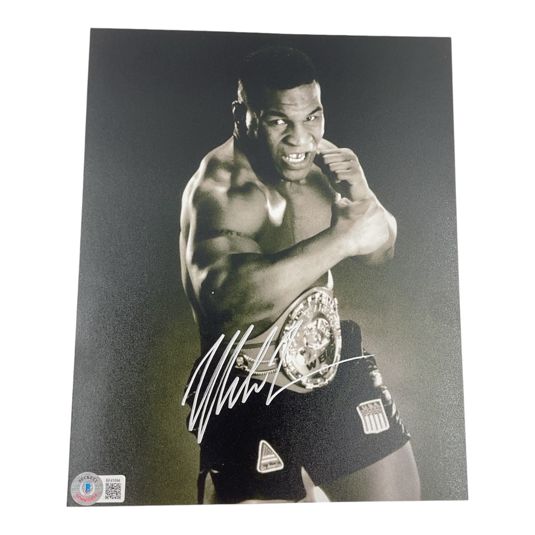 Mike Tyson Signed Championship Belt 10x8 Boxing Photo (Beckett COA): An iconic piece of boxing history memorabilia, this powerful matte-finish black and white photograph captures the legendary "Iron" Mike Tyson in a classic, menacing fighter's stance wear