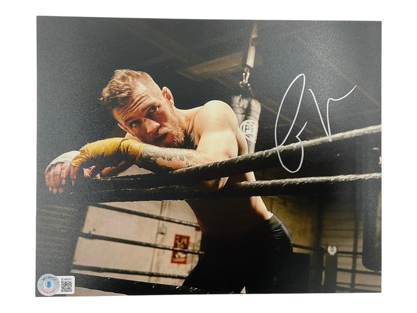 Conor McGregor Signed Training in Ring 10x8 Photo (Beckett COA): An exceptional piece of combat sports history memorabilia, this atmospheric matte-finish photograph captures the legendary "Notorious" Conor McGregor leaning against the ropes during an inte