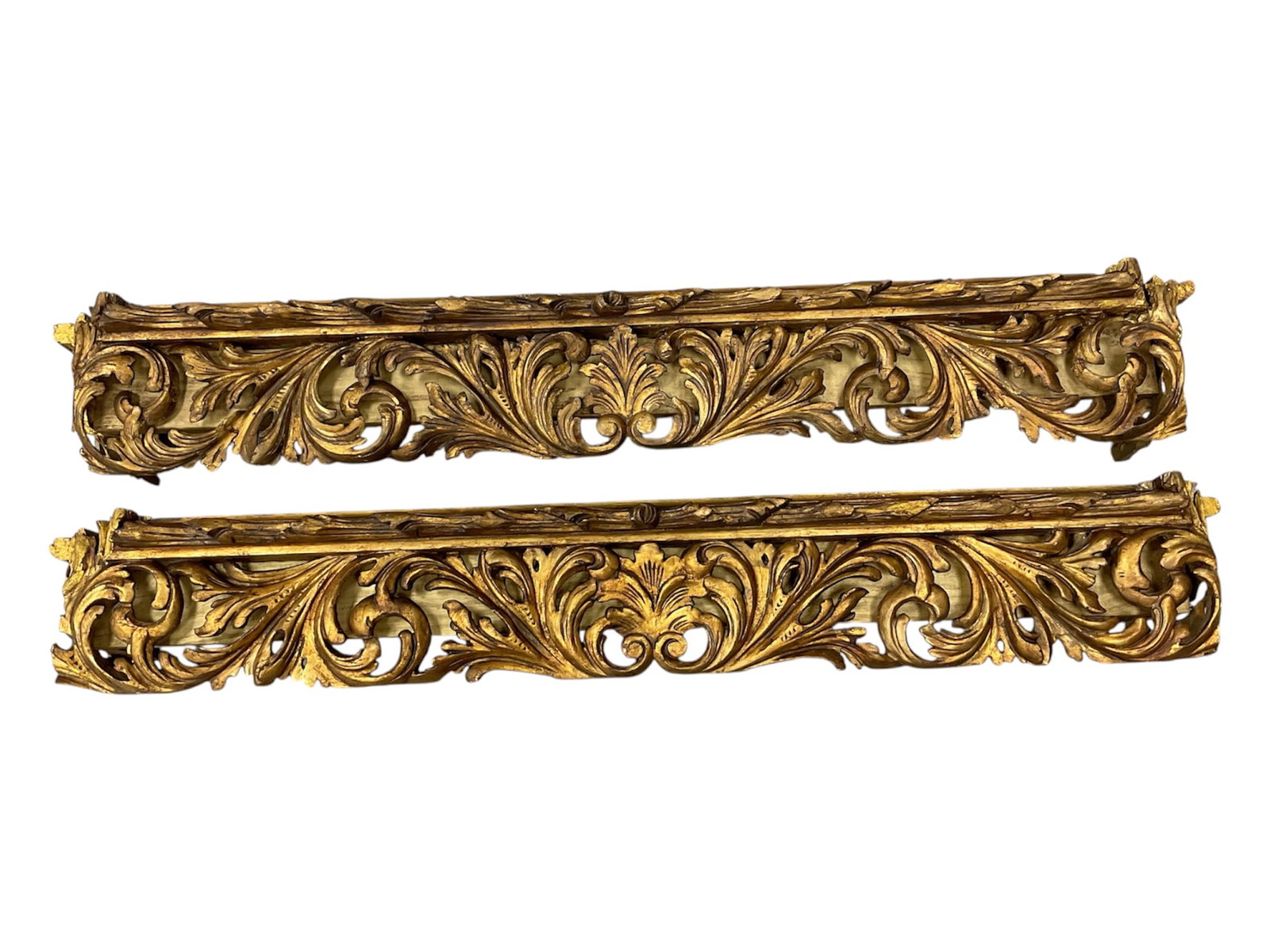 Pair of Antique Italian Giltwood Architectural Fragments: A magnificent pair of large-scale antique Italian architectural fragments, originally serving as ornate over-door pediments or valance cornices. Each piece features elaborate hand-carved openwork in a