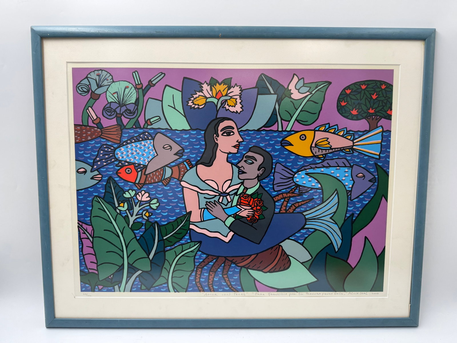"Amor Con Peces" by Alicia Leal (Cuba, b.1957) Lithograph: Description: Framed print titled "Amor Con Peces" by Alicia Leal. The print depicts a couple with a child surrounded by fish and flora in a vibrant, colorful style. Signed and numbered 63/10