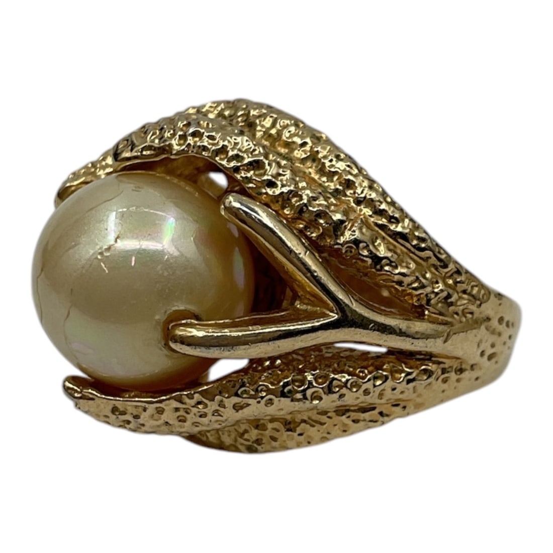 10kt Gold Pearl Ring: A 10kt yellow gold ring featuring a central pearl set within an ornate textured setting. The design displays a sculptural, organic form with raised detailing surrounding the pearl, creating a bold and
