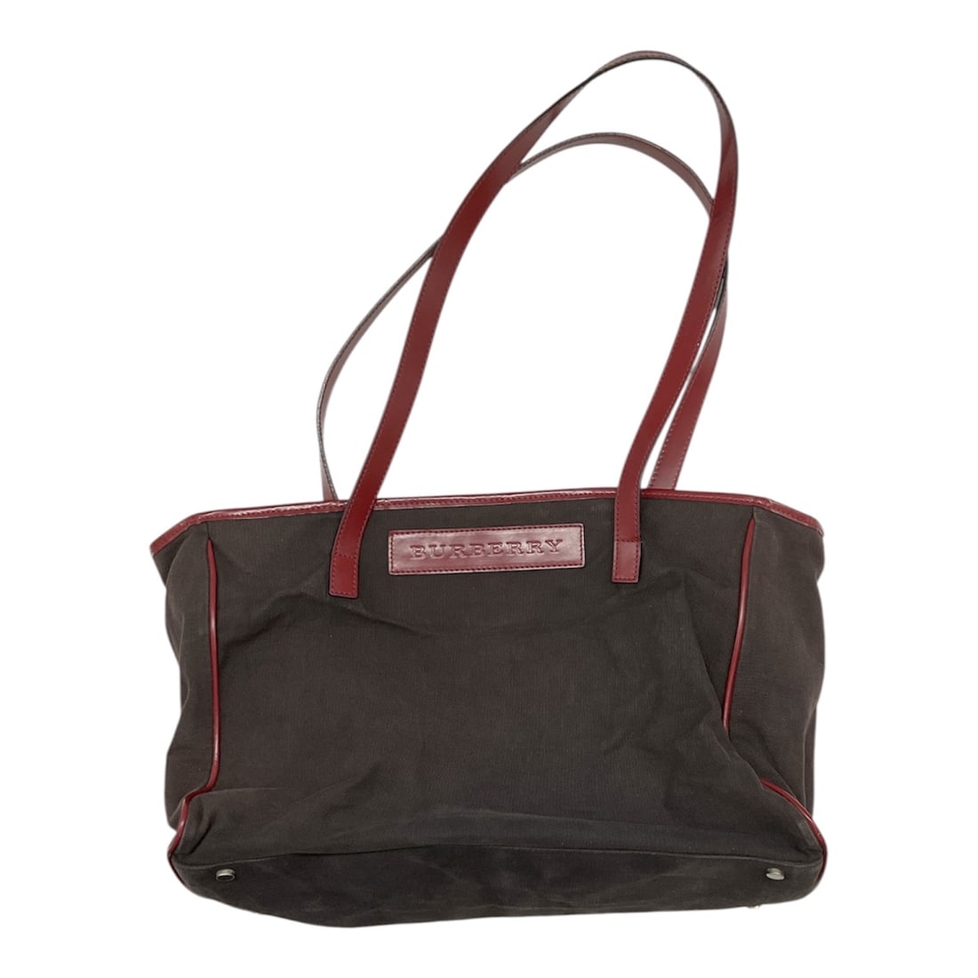 Burberry London Canvas Tote Bag with Red Leather Trim: Burberry London tote bag crafted in dark brown canvas with contrasting red leather trim and dual shoulder straps. Features a minimalist exterior with embossed Burberry leather logo plaque on the front