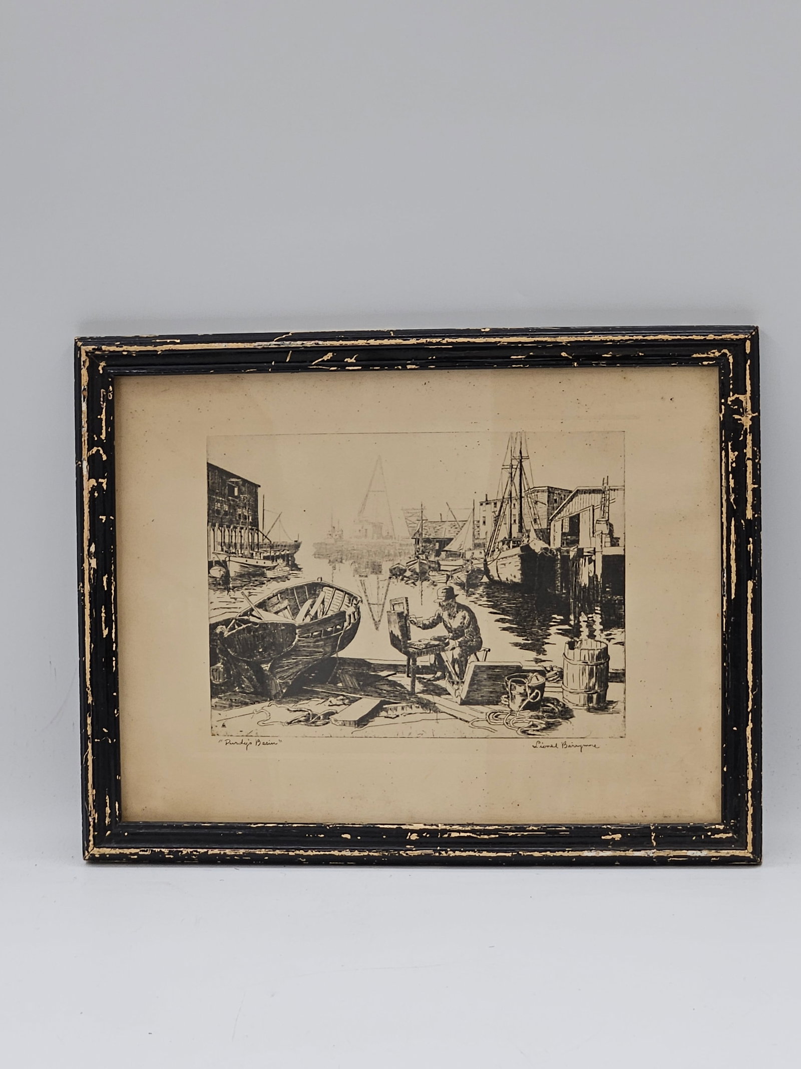 Purdy’s Basin by Lionel Barrymore: A black-and-white etching titled Purdy’s Basin by renowned actor and artist Lionel Barrymore. The work depicts a bustling harbor scene with boats and fishermen along the dock, capturing