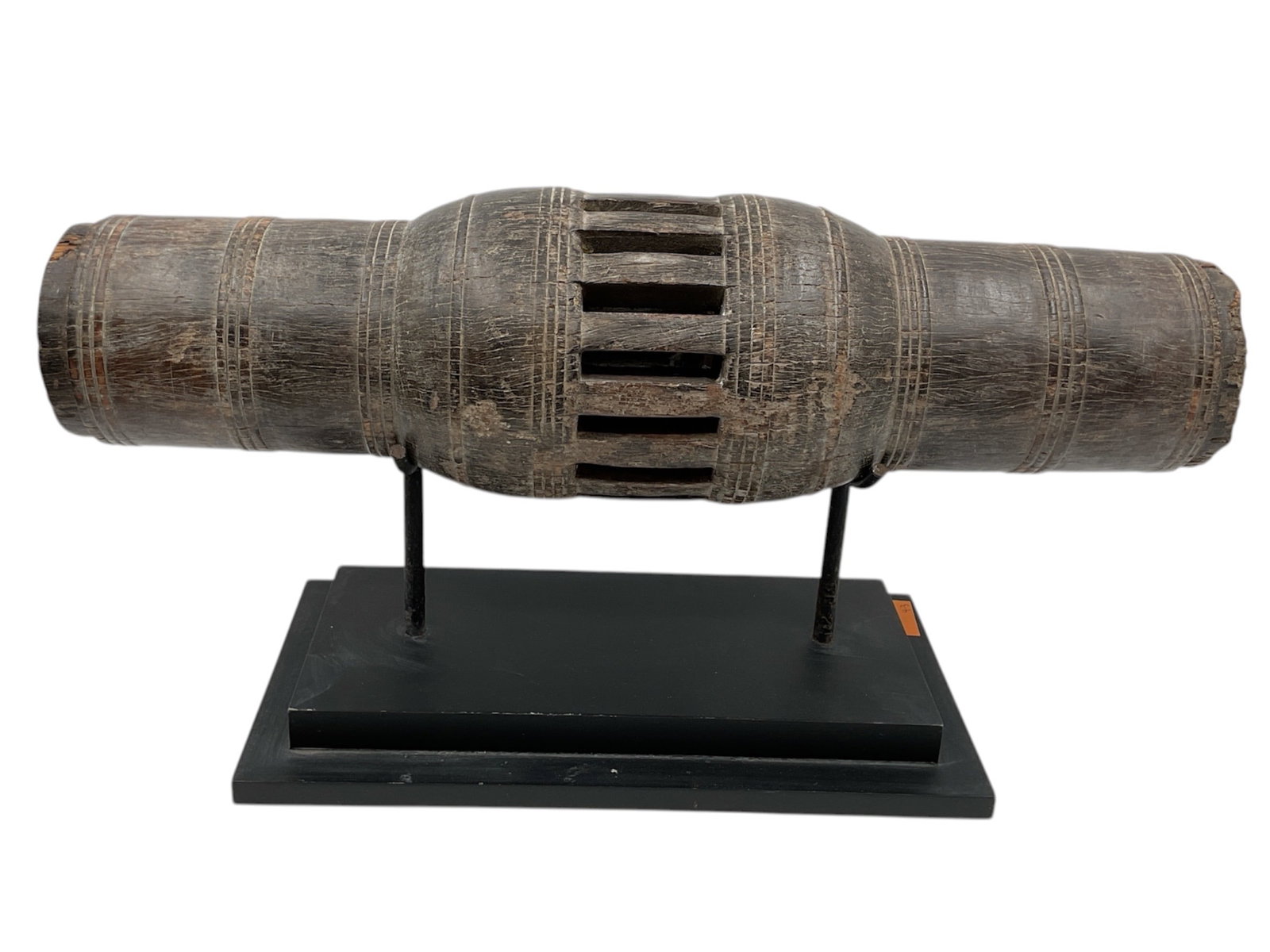 Antique Wooden Wagon Wheel Hub on Stand: An antique wooden wagon wheel hub, likely of Asian origin, featuring a cylindrical form with carved banded detailing and central openings where spokes would have been fitted. The piece is mounted on a