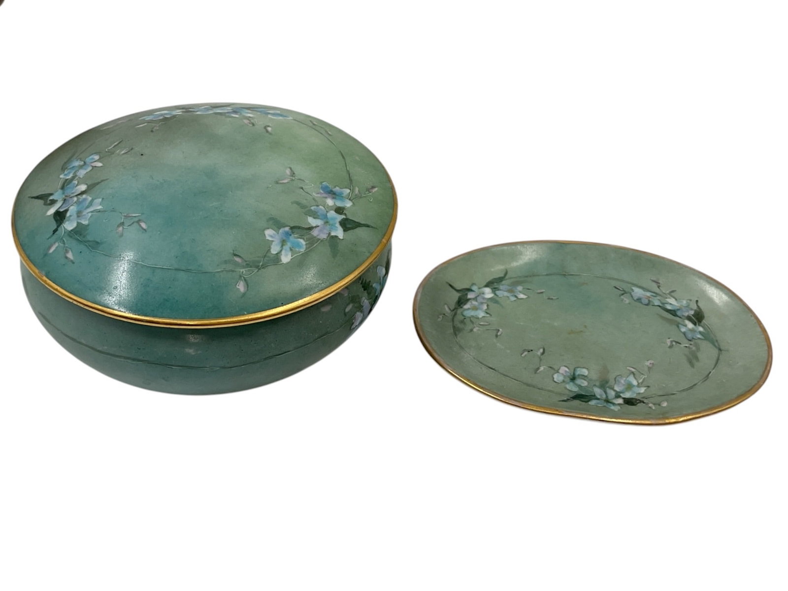 Vienna Austria Hand-Painted Porcelain Dresser Box: Oval porcelain dresser box and cover decorated in a soft green ground with hand-painted floral sprays and gilt accents. The underside bears a green Vienna Austria mark. Suitable for use as a trinket b