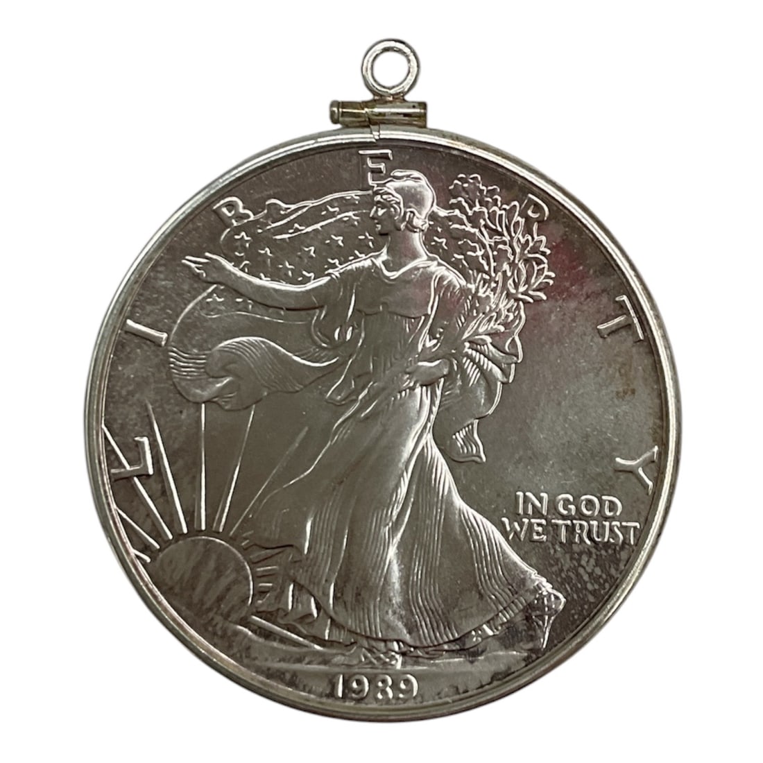 Sterling Silver Walking Liberty Pendant, Dated 1939: Sterling silver pendant modeled after the iconic 1939 Walking Liberty Half Dollar design. The obverse depicts Liberty striding toward the rising sun while draped in the American flag and carrying bran