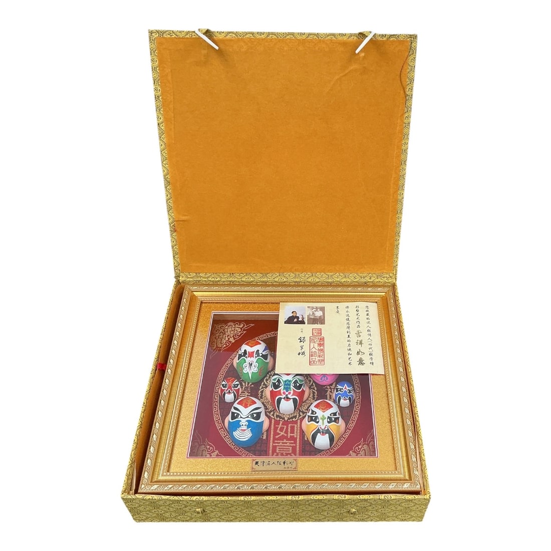 Framed Chinese Peking Opera Mask Shadow Box with Certificate: Decorative Chinese shadow box featuring a collection of colorful Peking (Beijing) Opera masks arranged against a red brocade-style background with auspicious Chinese characters. The presentation