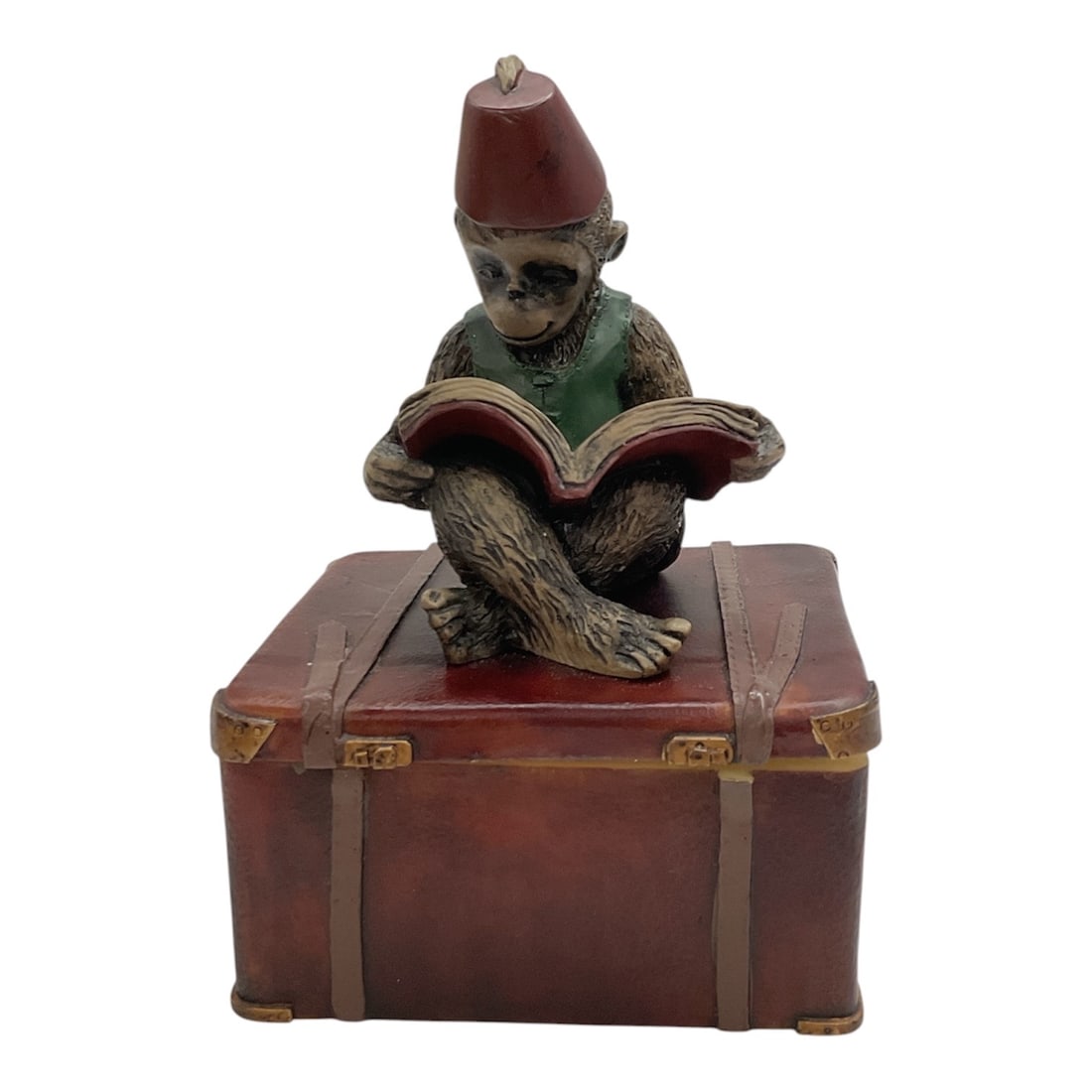 Vintage Dezine Monkey on Suitcase Trinket Box: This vintage Dezine trinket box features a whimsical monkey seated atop a faux-leather suitcase while reading a book. Crafted from hand-painted resin, the figure wears a red fez and green vest, with t