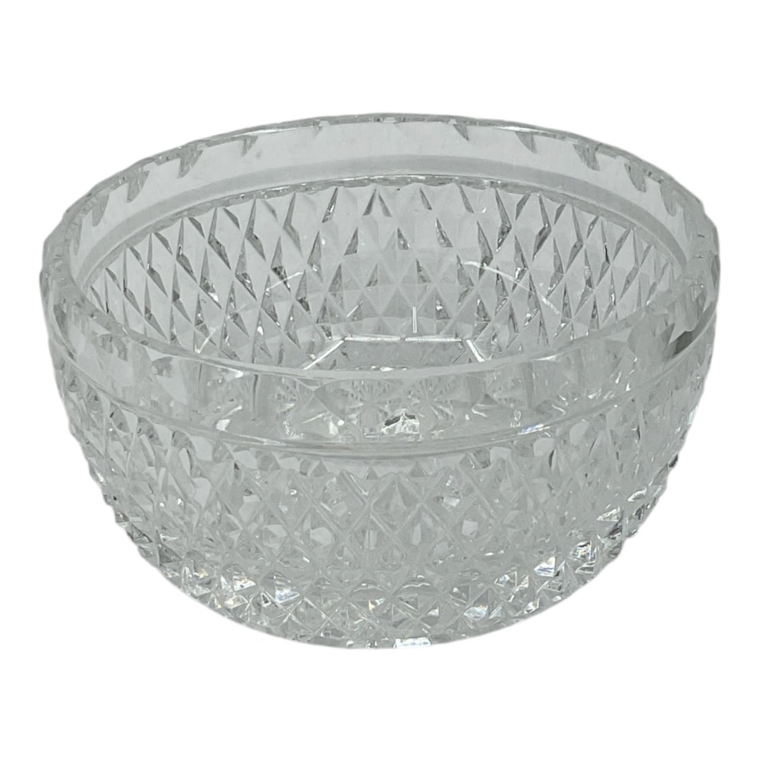 Cut Crystal Bowl: Clear cut crystal bowl featuring diamond and geometric cut decoration with faceted sides and decorative rim border. Compact circular form suitable for serving nuts, candies, or decorative tabletop dis