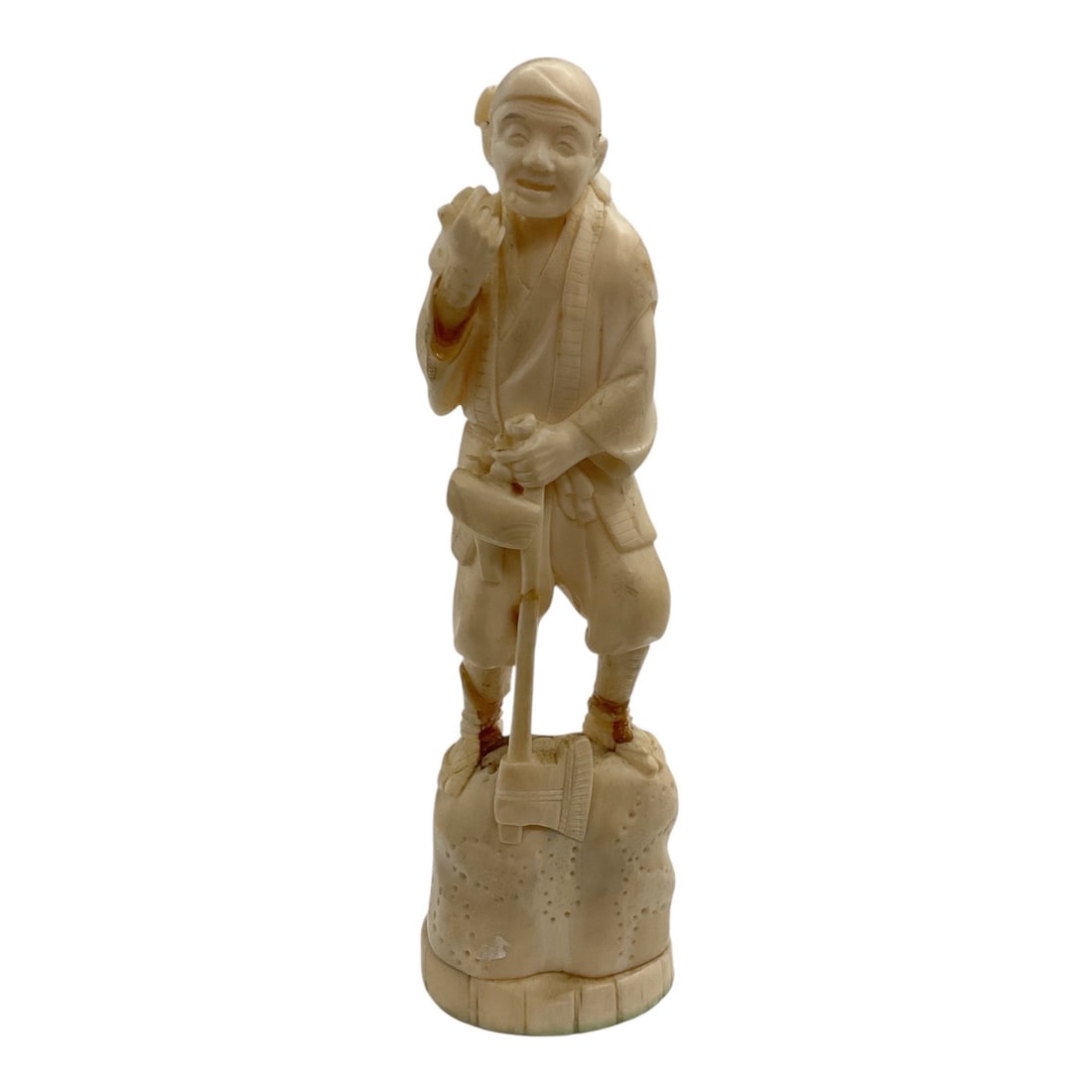 Asian-Style Carved Fisherman Figural Sculpture: A detailed Asian-style carved figural sculpture depicting a standing fisherman or village figure dressed in traditional attire. The figure is shown holding a fish over one shoulder and carrying a bask
