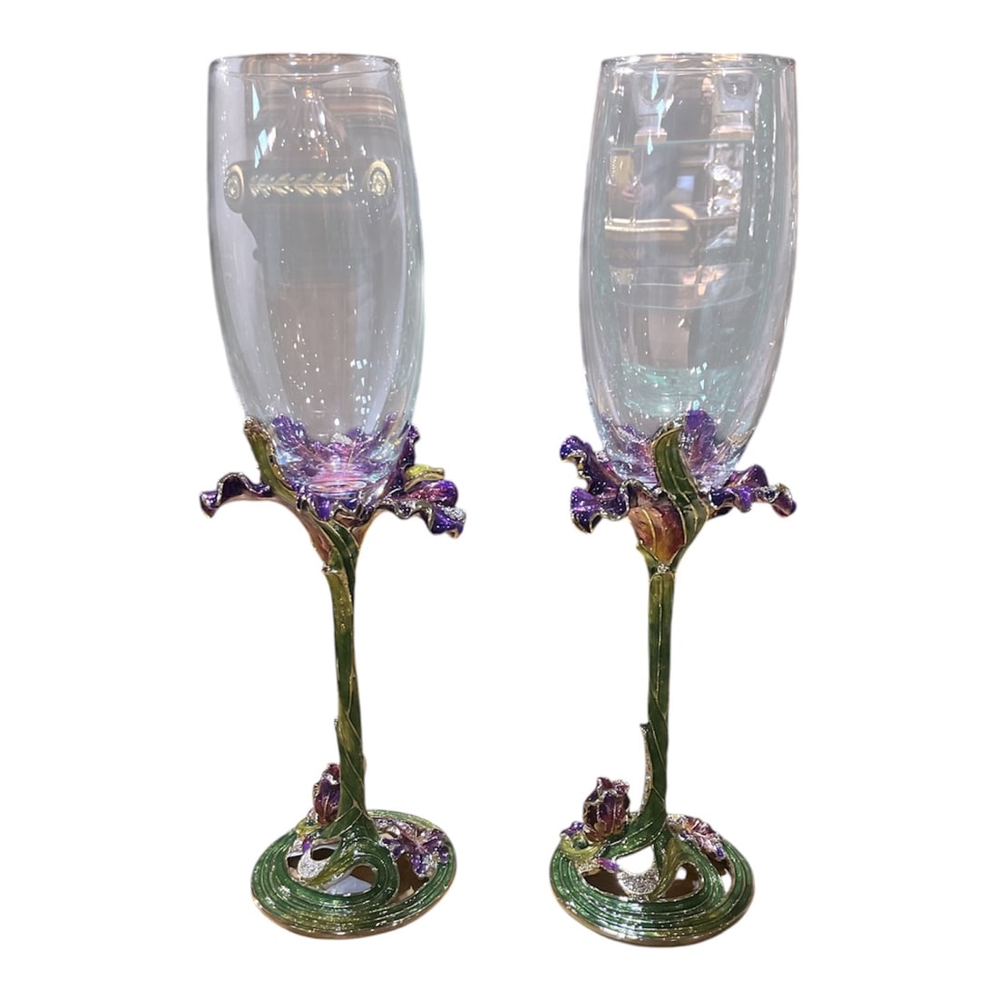 CS658 - Pair of Crystal and Enamel Champagne Glasses with Floral Stems: A highly decorative pair of champagne glasses combining clear crystal bowls with intricately enameled stems in a naturalistic floral design. Each glass features a tall, gently tapered bowl, offering