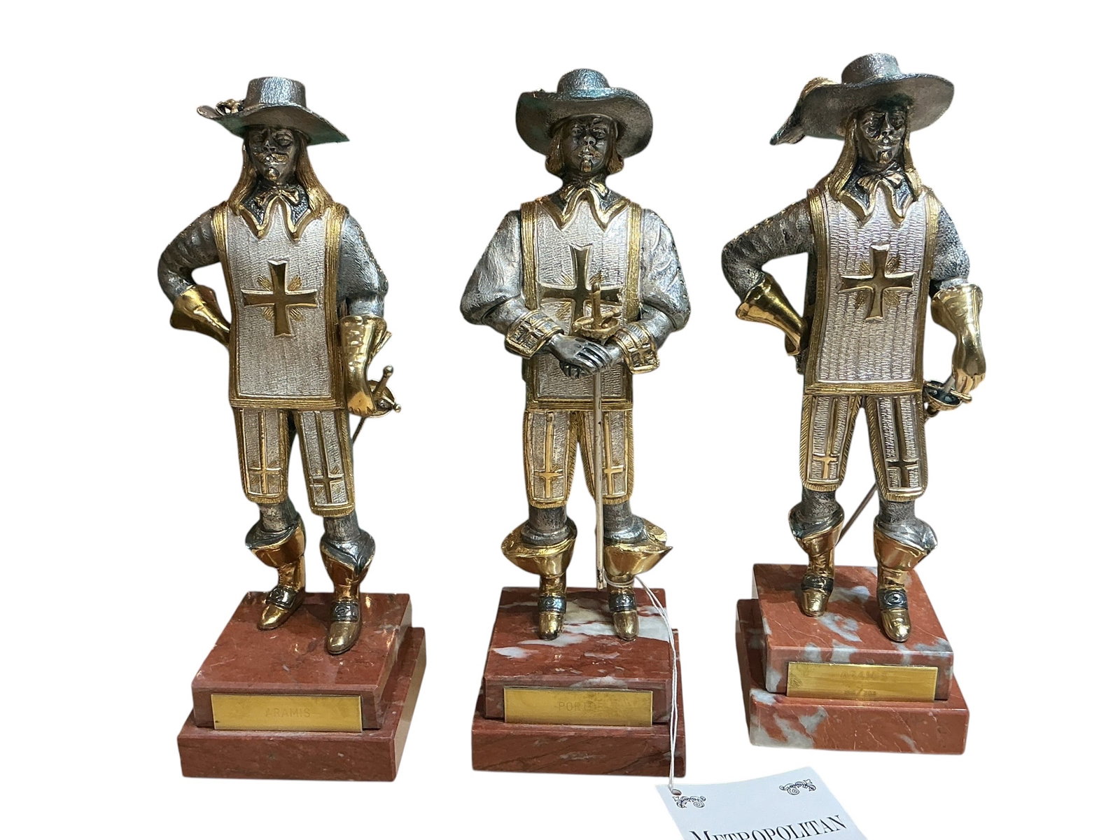 BR267- Set of Three Musketeer Figures in Bronze with Gold Finish on Marble Bases: A decorative set of three musketeer figures crafted in bronze with a gold-toned finish, each mounted on a polished marble base. The figures are rendered in detailed period attire, depicting the