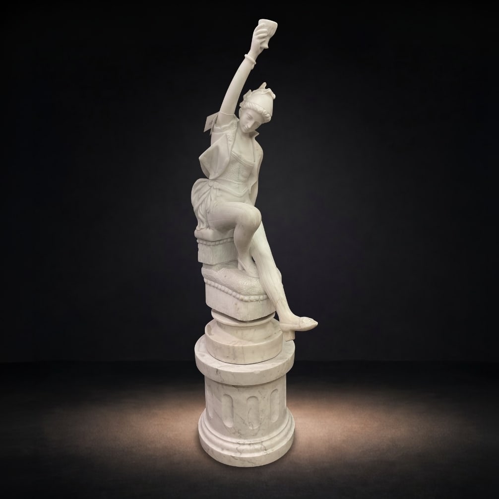 MB018 - Italian Marble Figural Sculpture of a Seated Maiden Holding a Cup: A finely carved Italian marble sculpture depicting a seated maiden in a graceful and expressive pose, rendered in the classical tradition. The figure is shown perched upon a naturalistic support above
