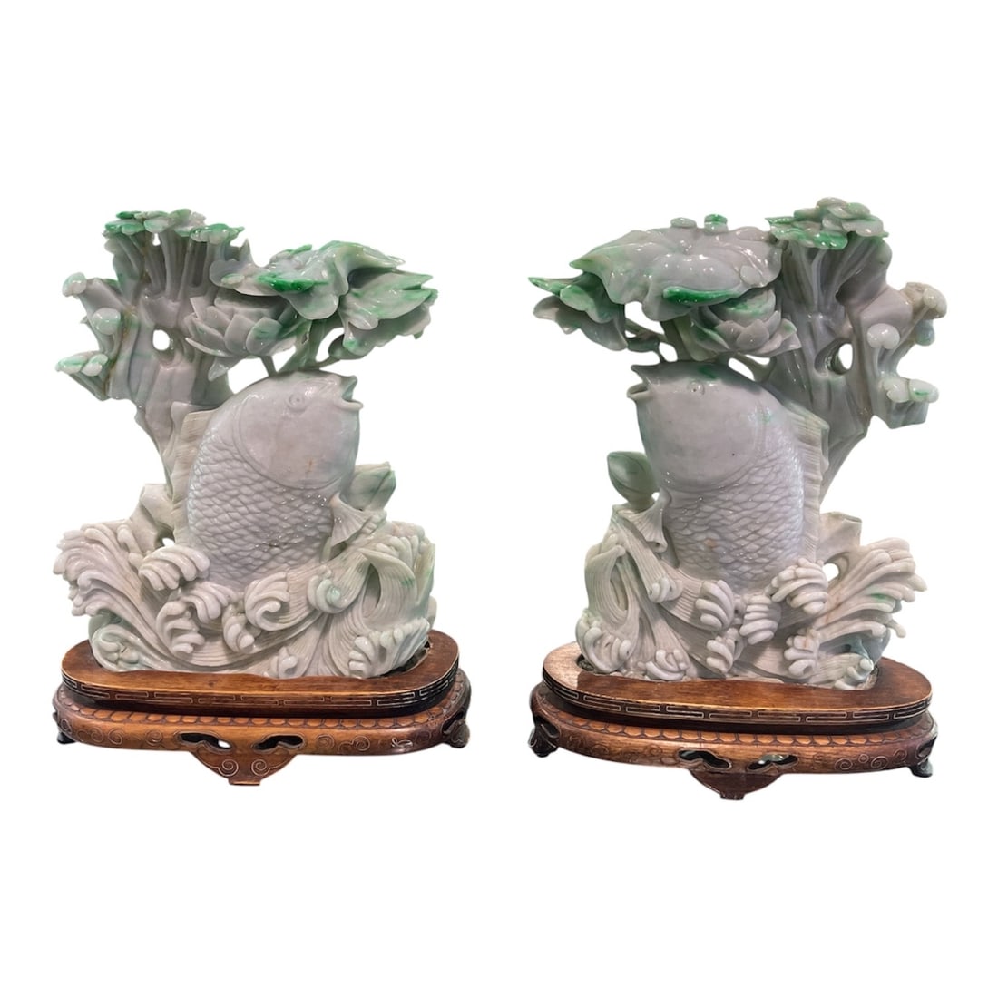JD821 - Pair of Carved Jade Koi Fish with Lotus on Hardwood Stands: A beautifully executed pair of jade sculptures depicting koi fish swimming among lotus leaves, a traditional motif rich in symbolism within Chinese culture. Representing prosperity, perseverance, and 