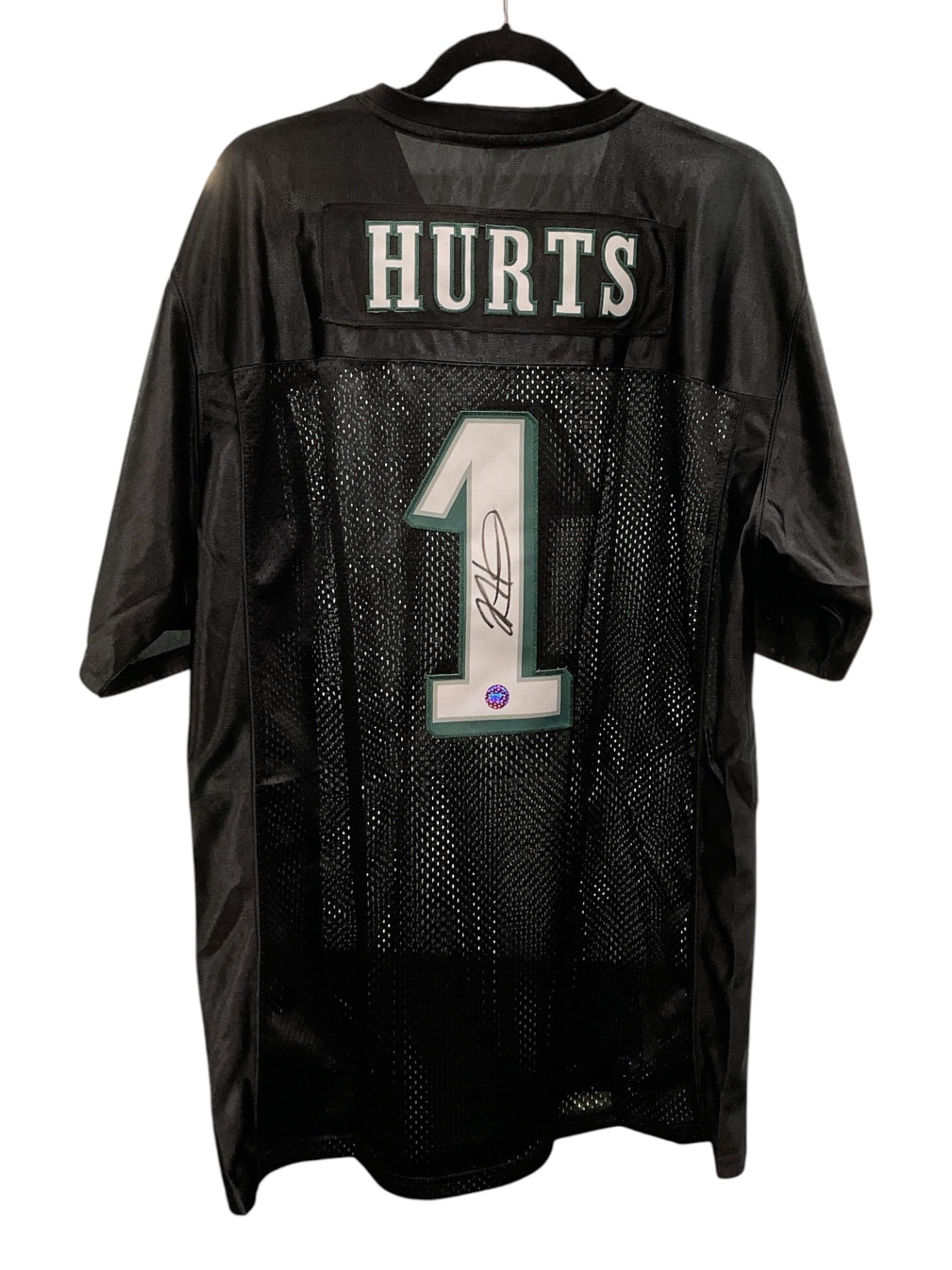 Jalen Hurts Signed Philadelphia Eagles Jersey: Black Philadelphia Eagles jersey featuring the name "Hurts" and number "1" on the reverse, boldly signed by quarterback Jalen Hurts in black marker across the numeral. The autograp