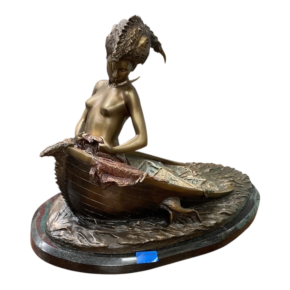 "Barco" by Carlos Verdial (Cuban, 1944-2012) Patinated Bronze Sculpture: This striking surrealist work features a stylized, partially nude female figure emerging from a small boat navigating turbulent, textured waves. Her hair or headpiece cascades backward in an elaborate