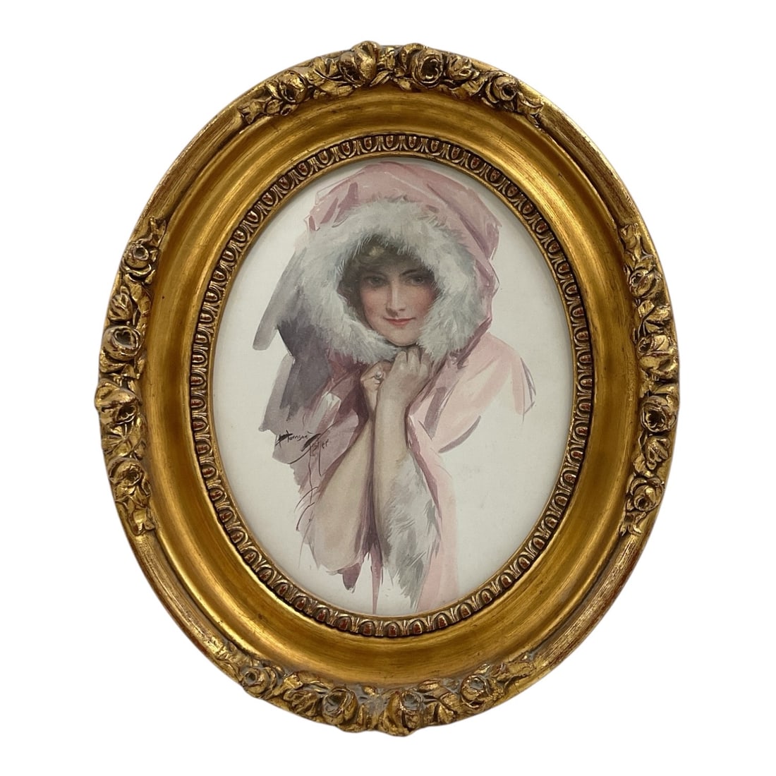 Harrison Fisher (American, 1875-1934) Framed Lady Portrait Print: An oval illustration depicting a young woman wrapped in a draped pink hood lined with soft white fur. She is rendered with fine detail, drawing focus to her centered gaze and direct expression set aga