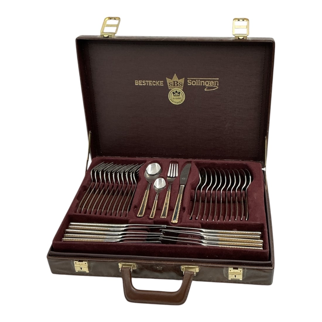 SBS Solingen 24K Gold Electroplate Flatware Service in Case: SBS Solingen flatware service housed in its original fitted presentation case. Manufactured in Solingen, Germany, the set features stainless steel flatware with
