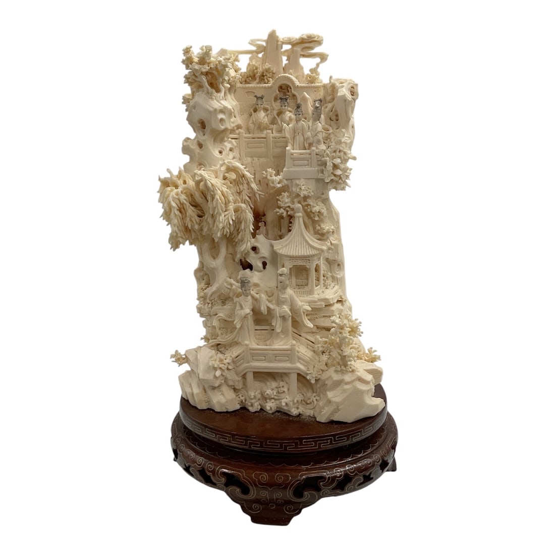 Asian-Style Intricately Carved Village Scene Sculpture: An elaborate Asian-style carved sculpture featuring a densely detailed village and landscape scene with multiple figures, tiered architectural structures, trees, foliage, and openwork elements. The
