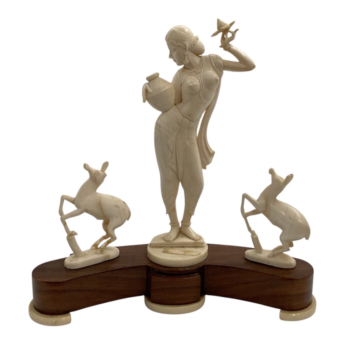 Asian-Style Female Figure with Antelope Sculptural Group: A decorative Asian-style figural sculpture featuring a standing female figure flanked by two leaping antelope or deer. The central figure holds a vessel in one hand with a small bird perched upon the