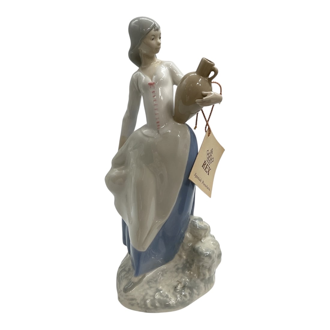 Rex Valencia Spanish Porcelain Lady Holding Jug Figurine: Handmade Spanish porcelain figurine by Rex Valencia depicting an elegant young woman holding a jug. The figure is modeled in a graceful standing pose and finished in a glossy glaze with soft blue and