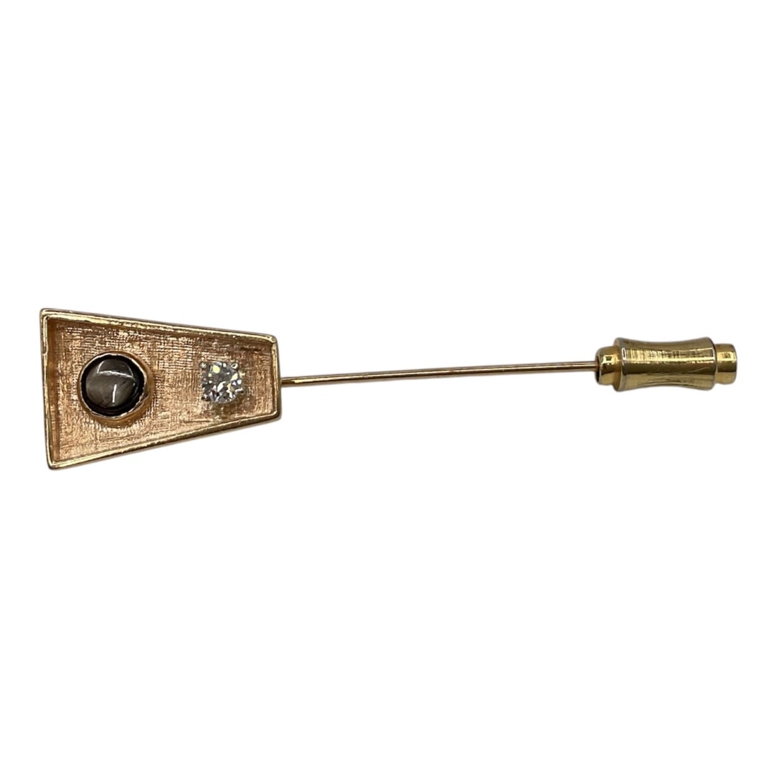 Antique Art Deco Yellow Gold Onyx and stone Stick Pin: Antique Art Deco stick pin featuring a geometric trapezoidal head in a yellow-gold setting. The design is accented with a round black onyx cabochon and a small diamond, combining contrasting tones wit