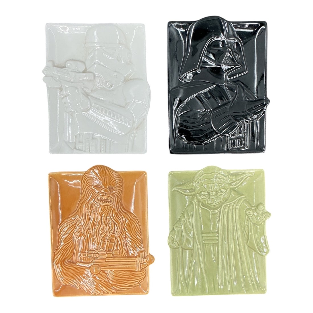 Set of Four Star Wars Character Ceramic Trays: Set of four ceramic trinket trays featuring iconic Star Wars characters in raised relief, including Darth Vader, Stormtrooper, Chewbacca, and Yoda. Each rectangular tray is fi