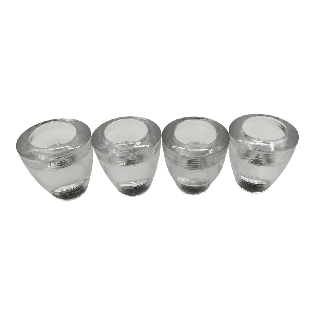 Set of Four Clear Glass Decorative Vessels: This set of four clear glass decorative vessels features a heavy, rounded form with thick walls and polished surfaces. Their clean, minimalist design and substantial weight make them suitable for a va