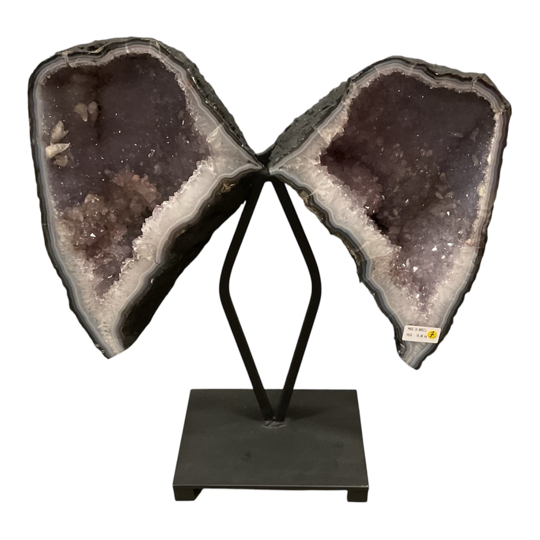 Brazilian Amethyst Butterfly Geode on Metal Stand: A striking natural amethyst display composed of two matched geode halves arranged in the form of butterfly wings. Each section reveals a sparkling interior of pale lavender-to-purple amethyst crystals