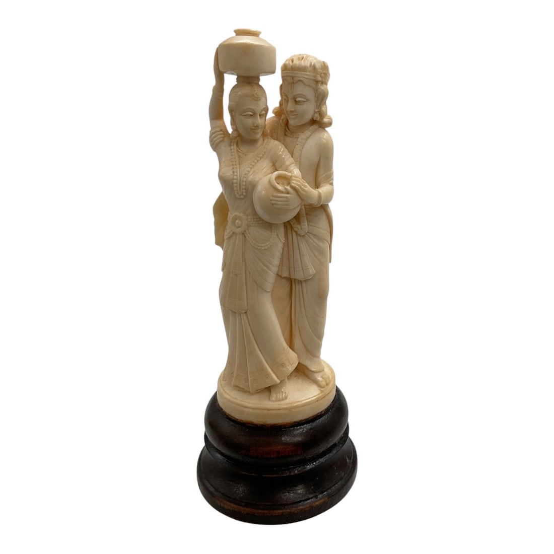 Asian-Style Carved Figural Sculpture of Two Women: A detailed Asian-style carved figural sculpture depicting two standing women in traditional attire. One figure balances a vessel upon her head while the second stands closely alongside, with both figu